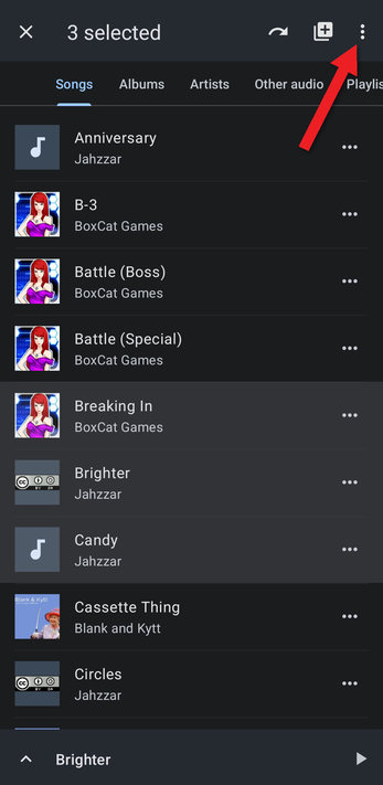 Three songs selected with an arrow pointing at the menu button